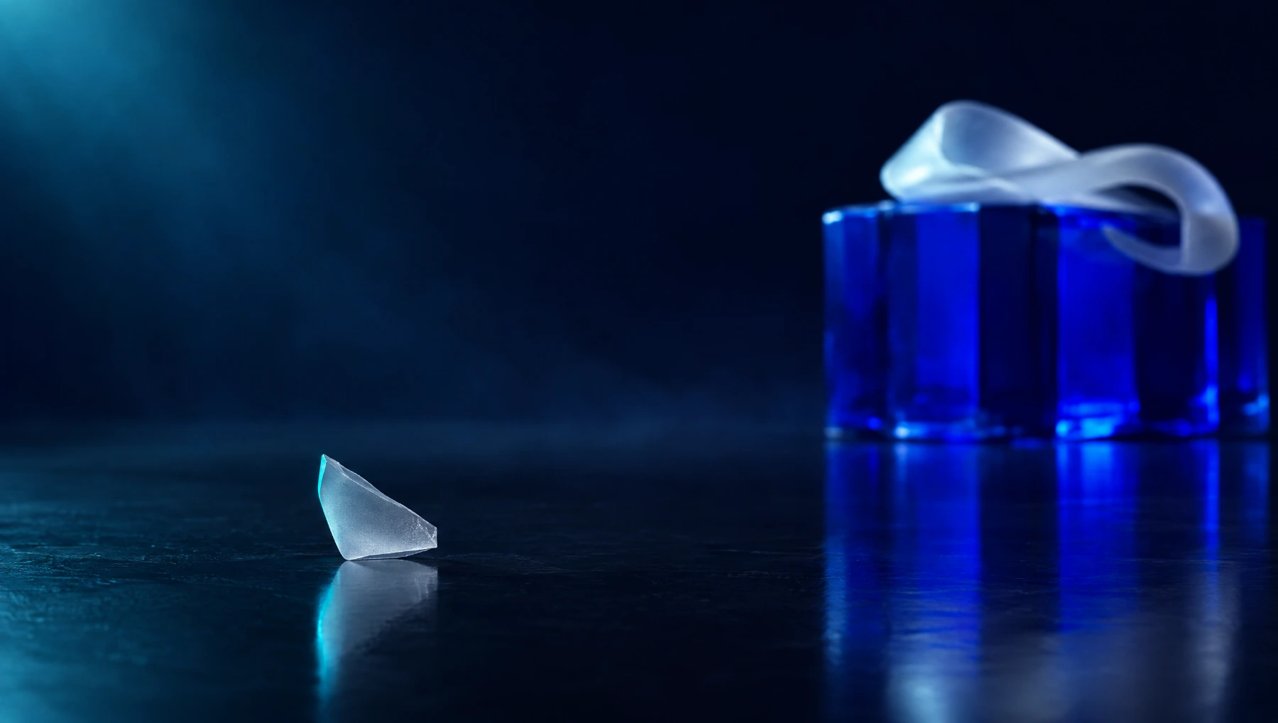 A lone glass fragment on the floor, far from the blue block